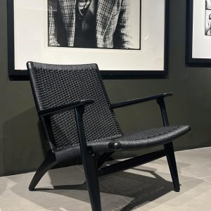 Fauteuil CH25 Hans Wegner : ce fauteuil design haut de gamme signé Hans J. Wegner en 1952 pour Carl Hansen reste une icône intemporelle du design scandinave. Sa structure en bois massif de chêne noir offre une robustesse et une élégance naturelle tandis que l’assise et le dossier en corde de papier noir tressée à la main procurent un confort exceptionnel et une respiration parfaite. Avec ses dimensions 71 x 73 x 73 H cm, il allie proportions harmonieuses et présence affirmée. Véritable pièce de decoration haut de gamme, il séduit les décorateurs d’intérieur, ensembliers, décorateurs et architecte qui recherchent un fauteuil à la fois historique et résolument moderne. Bel Œil, spécialiste du mobilier haut de gamme, le présente dans ses showrooms. Vous cherchez un fauteuil iconique et confortable pour vos projets à Nice, Cannes, Monaco, Marseille ou Saint Tropez ? Le Fauteuil CH25 Hans Wegner répond parfaitement aux exigences des réalisations d’art et de decoration haut de gamme. La corde de papier noir tressée à la main crée un contraste raffiné avec le chêne noir, offrant une texture unique et un confort moelleux. Sa structure en bois massif assure une durabilité exceptionnelle tout en conservant une légèreté visuelle. Bel Œil accompagne architectes, décorateurs et particuliers dans leurs projets d’aménagement intérieur sophistiqués. Nous excellons en tant qu’ensemblier et décorateur d’intérieur pour créer des espaces de vie d’exception. Découvrez l’art du fauteuil design avec Bel Œil, votre référence à Marseille, Nice, Cannes, Monaco et Saint Tropez. Ce modèle Carl Hansen incarne l’alliance parfaite entre héritage du design danois et savoir-faire artisanal. Sa silhouette iconique de 1952 continue d’inspirer les intérieurs contemporains les plus raffinés. Faites confiance à notre expertise en mobilier design haut de gamme, art de vivre et aménagement pour sublimer vos espaces avec une pièce chargée d’histoire et de modernité.
