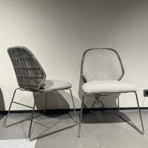 Chaise Crinoline Patricia Urquiola : cette chaise d’extérieur haut de gamme conçue par Patricia Urquiola pour B&B Italia est une véritable sculpture fonctionnelle. Sa structure en aluminium tourterelle est recouverte d’une poudre de polyester résistante aux intempéries, tandis que le siège est réalisé en fibre de polyéthylène tissée main dans un élégant ton tourterelle. Avec ses dimensions L 61 cm x P 57 cm x H 80 cm, elle offre une assise confortable et une silhouette enveloppante aux courbes douces et organiques. Le tressage tridimensionnel crée un effet visuel léger et aérien tout en garantissant une excellente ventilation. Véritable pièce de decoration haut de gamme, cette chaise séduit les décorateurs d’intérieur, ensembliers, décorateurs et architecte qui recherchent un mobilier outdoor à la fois poétique, résistant et raffiné. Bel Œil, spécialiste du mobilier haut de gamme, la présente dans ses showrooms. Vous cherchez une chaise d’extérieur élégante et sculpturale pour vos projets à Nice, Cannes, Monaco, Marseille ou Saint Tropez ? La Chaise Crinoline Patricia Urquiola répond parfaitement aux exigences des réalisations d’art et de decoration haut de gamme en extérieur. Son design inspiré des crinolines anciennes revisité de manière contemporaine offre un mélange unique de douceur et de modernité. Le tressage en fibre de polyéthylène tourterelle apporte une texture riche et une grande durabilité face au soleil, à l’humidité et au sel marin. Bel Œil accompagne architectes, décorateurs et particuliers dans leurs projets d’aménagement extérieur sophistiqués. Nous excellons en tant qu’ensemblier et décorateur d’intérieur pour créer des espaces de vie d’exception en plein air. Découvrez l’art de la chaise outdoor design avec Bel Œil, votre référence à Marseille, Nice, Cannes, Monaco et Saint Tropez. Ce modèle B&B Italia incarne l’alliance parfaite entre la créativité audacieuse de Patricia Urquiola et le savoir-faire italien en mobilier d’extérieur. Sa forme sinueuse et son tressage artisanal en font une chaise signature pour les terrasses, jardins et bord de piscine les plus raffinés. Faites confiance à notre expertise en mobilier design haut de gamme, art de vivre et aménagement extérieur pour sublimer vos espaces avec une pièce unique et inoubliable.