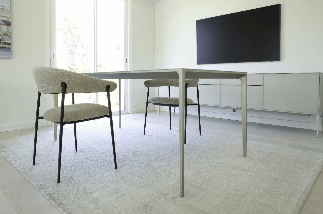 Cette vue de la salle à manger de la Maison Carry montre comment le mobilier design peut participer à l’identité d’un intérieur sans en devenir l’unique sujet. La table Long Island de Rimadesio structure l’espace repas avec ses lignes contemporaines et son dessin particulièrement épuré. Associée aux chaises choisies pour le projet, elle crée un ensemble à la fois élégant et accueillant. La maison, située près de Marseille sur la Côte Bleue, a été aménagée avec l’accompagnement de Bel Œil Marseille. Les clients connaissaient déjà l’univers Rimadesio et souhaitaient retrouver dans leur intérieur la sobriété et la précision de la marque italienne. Le projet ne repose pourtant pas uniquement sur le choix de produits Rimadesio : chaque pièce a été pensée pour pouvoir dialoguer avec l’ensemble de la décoration, les volumes de la maison et les usages quotidiens. C’est cette approche globale qui donne à la réalisation son caractère résidentiel. Le mobilier contemporain apporte une écriture graphique, tandis que les différents matériaux et éléments décoratifs permettent de conserver une atmosphère chaleureuse. Maison Carry devient ainsi un exemple d’aménagement intérieur où le design italien s’intègre naturellement à une maison de vie.
